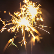 A hand holding two sparklers